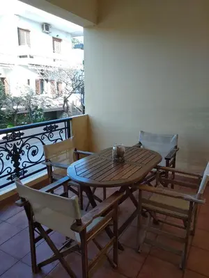 a wooden table and chairs on a balcony at Ton Mari Apartments in Palaiochóra