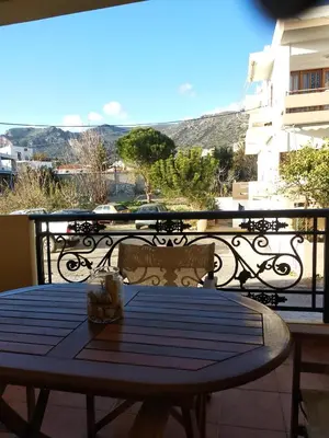 a table on a balcony with a view at Ton Mari Apartments in Palaiochóra