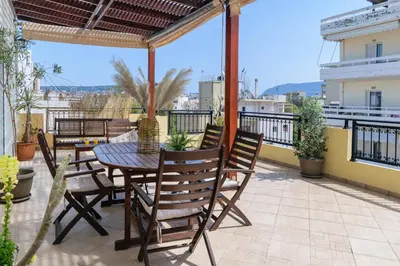 a patio with a table and chairs on a balcony at Central penthouse in quiet neighborhood near sandy beach in Chania Town