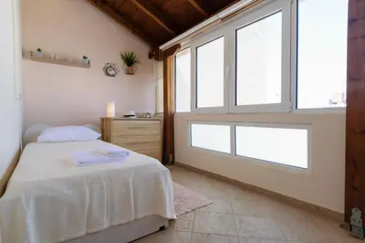 a bedroom with a bed and two windows at Central penthouse in quiet neighborhood near sandy beach in Chania Town