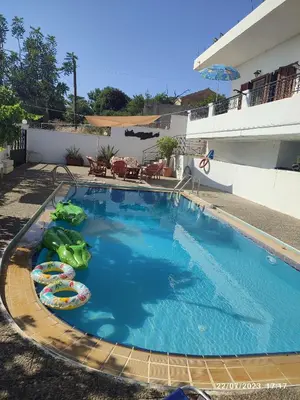 a large swimming pool with inflatables in front of a building at VILLA ANNA in Ravdhoúkha
