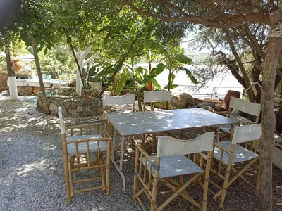 a table and chairs sitting under a tree at VILLA ANNA in Ravdhoúkha