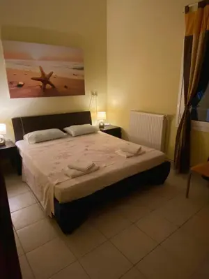a bedroom with a bed and a picture of a beach at VILLA ANNA in Ravdhoúkha