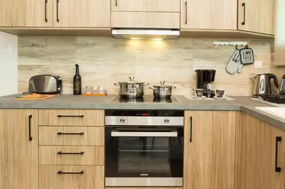 a kitchen with wooden cabinets and a stove top oven at Chrysa House Kissamos in Kissamos