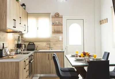 a kitchen with a table and chairs and a kitchen with a window at Chrysa House Kissamos in Kissamos