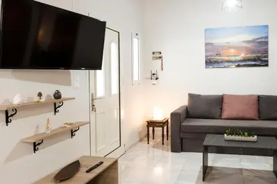 a living room with a couch and a flat screen tv at Chrysa House Kissamos in Kissamos