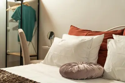 a bed with white pillows and a mirror at Mansion D in Galatás