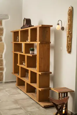 a wooden book shelf in a room with a table at Mansion D in Galatás