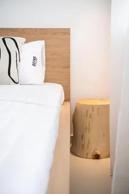 a bedroom with a bed and a nightstand next to a bed sidx sidx sidx at Astra boutique suites at Agia Marina Beach in Agia Marina Nea Kydonias