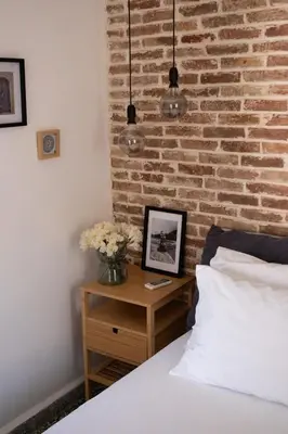 a bedroom with a brick wall and a table with a bed at MV Living - Residence in Chania Town