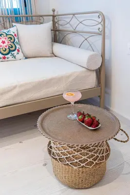 a coffee table with a bowl of strawberries on a bed at Villaspo Homes in Chania Town