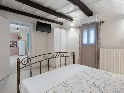 a bedroom with a bed and a tv on the wall at Villaspo Homes in Chania Town