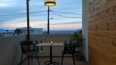 a table and chairs on a balcony with a view of the ocean at GioDriana cozy studio in Agia Marina Nea Kydonias