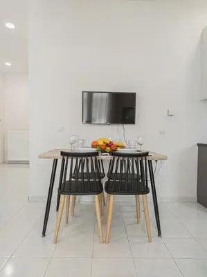 a table and chairs with a bowl of fruit on it at Fully renovated apartment in the city centre with roof garden! 3 minutes from the bus station and 6 minutes from the old town in Chania Town