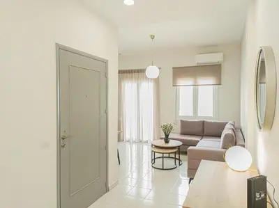 a living room with a couch and a table at Fully renovated apartment in the city centre with roof garden! 3 minutes from the bus station and 6 minutes from the old town in Chania Town