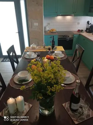 a kitchen with a table with flowers and a bottle of wine at nafsikacottagehouse in Kissamos