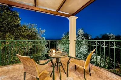 a patio with a table and chairs on a balcony at Villa Vallia - Villa Marina in Kato Galatas