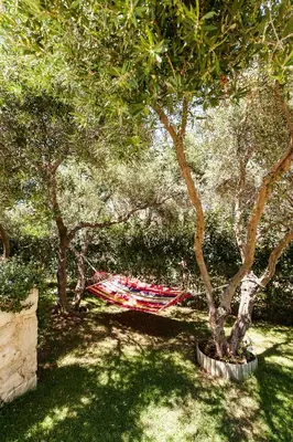 a red hammock under a tree in a park at Villa Vallia - Villa Marina in Kato Galatas