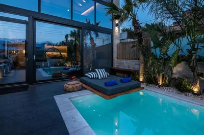 a house with a swimming pool with a couch next to it at Villa Armenus, private pool, garden, BBQ in Chania Town