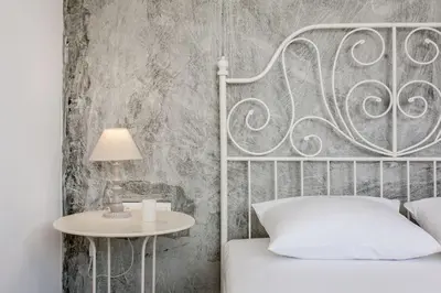 a bedroom with a bed and a table with a lamp at Glaros Studios in Kalamaki Chanion