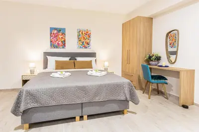 a bedroom with a bed with a desk and a chair at Gallery Art Apartment Chania Crete in Chania Town