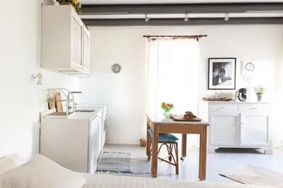 a kitchen with a table and a white refrigerator at Feána Home by 8essentially in Psathoyiánnos