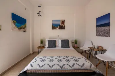 a bedroom with a bed and a table and chairs at Agiazi Beachfront Apartment in Chania Town