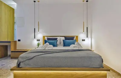 a bedroom with a large bed with blue pillows at Arch 4 Luxury Living in Chania Town