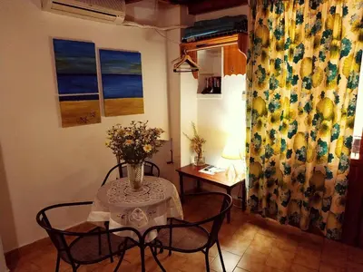 a table with chairs and a vase of flowers on it at Guesthouse Chryssoula in Chania Town