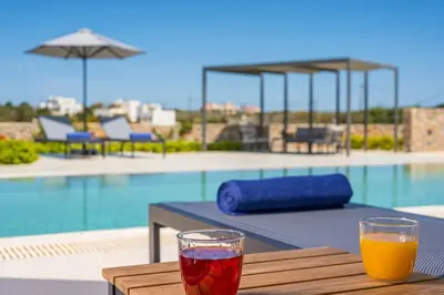 a drink sitting on a table next to a pool at Villa Afeidia in Tersanas