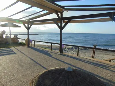 a view of the ocean from a beach with an umbrella at Comfy Beachfront Litinas Casa with SeaView in Chania Town