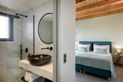 a bathroom with a bed and a sink next to a shower at Soleado Villa Chania rooftop heated pool in Chania Town