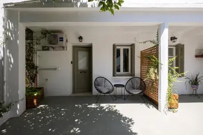 a patio with two chairs and a table and a door at MV Living - Studio in Chania Town