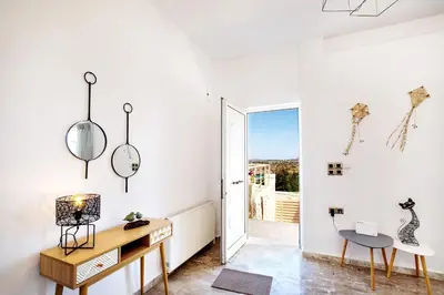 a white room with a desk and a chair at Vagioni Seaside Villa in Kounoupidhianá