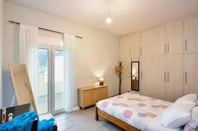 a bedroom with a bed and a large window at Souda apartment in Souda