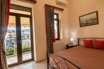 a bedroom with a bed and a large window at Calliope Rooms 1 in Kissamos