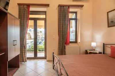 a bedroom with a bed and a window with curtains at Calliope Rooms 1 in Kissamos