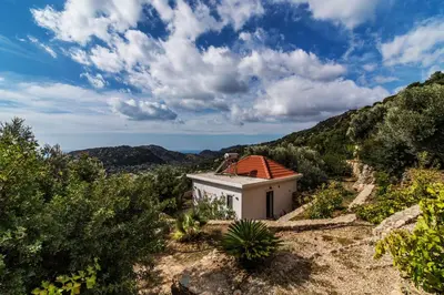 a small white building with a red roof at Christos Place-Anidri in Palaiochóra