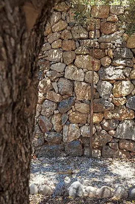 a stone wall with a tree in front of it at Christos Place-Anidri in Palaiochóra