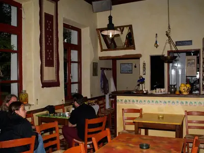 a group of people sitting at tables in a restaurant at Christos Place-Anidri in Palaiochóra
