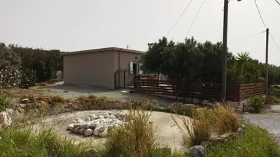 a flock of sheep laying on the ground in front of a building at Kedrodasos House in Elafonisi