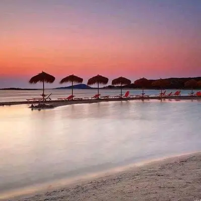 a group of umbrellas and chairs on a beach at Kedrodasos House in Elafonisi