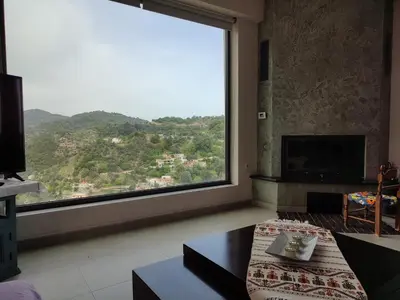 a living room with a large window with a view at Villa Lakki's Ori in Lákkoi