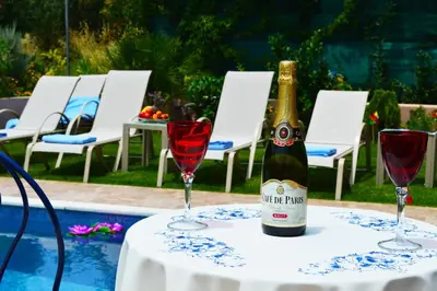 a bottle of wine sitting on a table with two glasses at Belle Verte Villa Maleme in Maleme