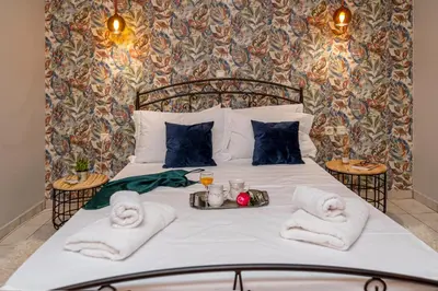 a bed with towels and a tray of food on it at Laurel Heights Apartment in Chania Town