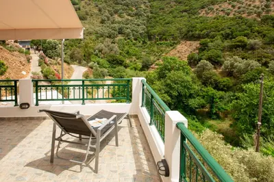a chair on a balcony with a view of a mountain at Villa Araxovoli in Palaiochóra
