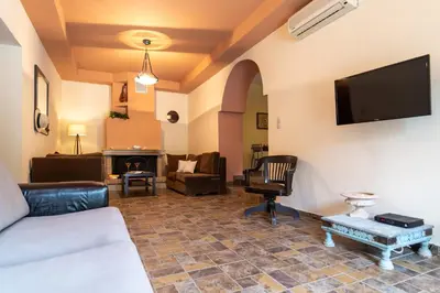 a living room with a couch and a tv on the wall at Villa Araxovoli in Palaiochóra