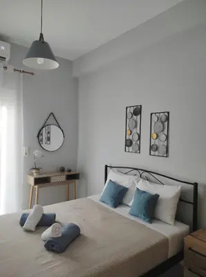 a bedroom with a large bed with blue pillows at Aura Estate in Chania Town