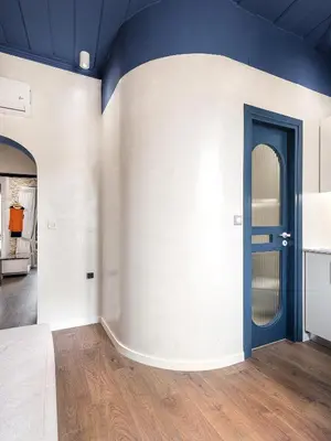 a room with a blue door on a white wall at New Boutique Venetian apartments - La Casa Nove in Chania Town