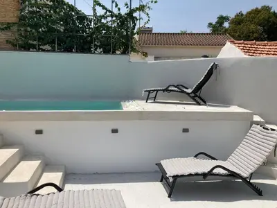 a patio with a bench and a swimming pool at Armenous Green Dia's Mansion in Arménoi